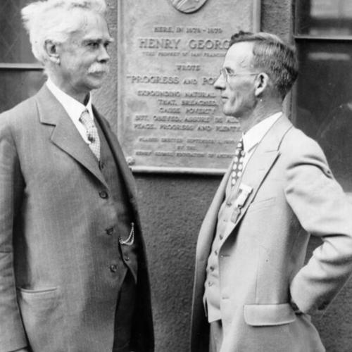 [Judge Jackson Ralston and A. J.  H. Milligan standing in front of a plaque  to Henry George]