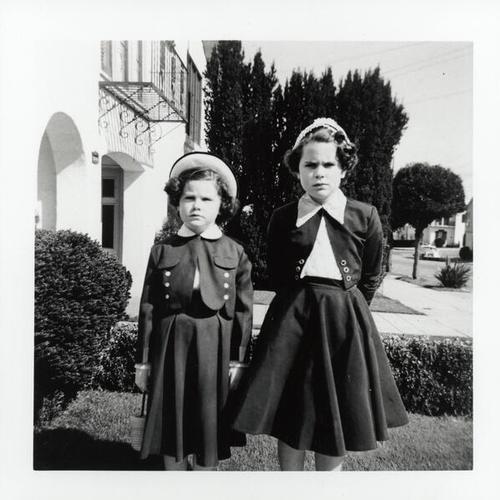 [Maureen with her sister Kathleen in front of their house]