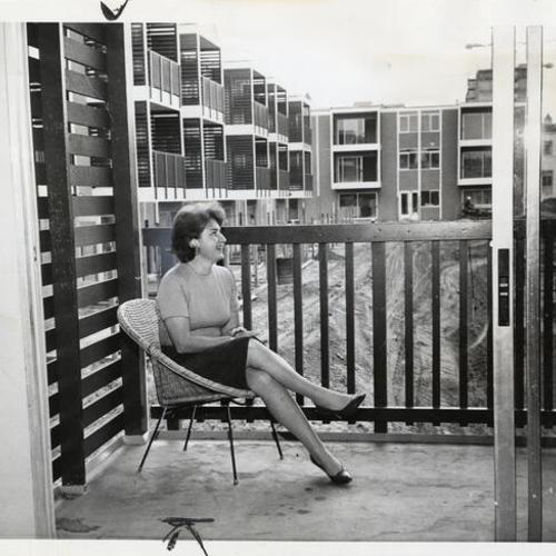 [Ruth Gottstein sitting on a balcony at St. Francis Square housing project]