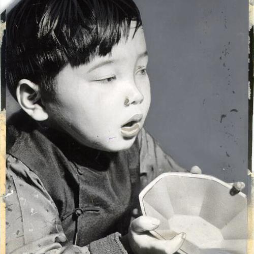 [Young boy holding up a bowl, Rice Bowl Party]