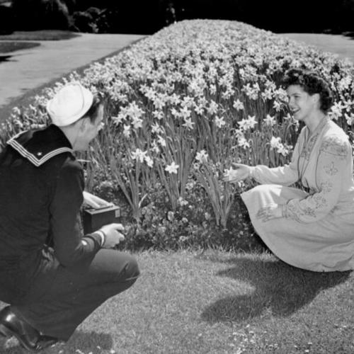 [Harold Andrew and fiancee Dorothy Micel, by the daffodil beds in Golden gate Park. The flowers will be part of the vast display of blossoms out this weekend]
