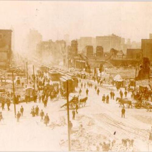 [Looking up Market Street from near the Ferry Building, showing laborers clearing debris and pedestrian and cable car traffic]