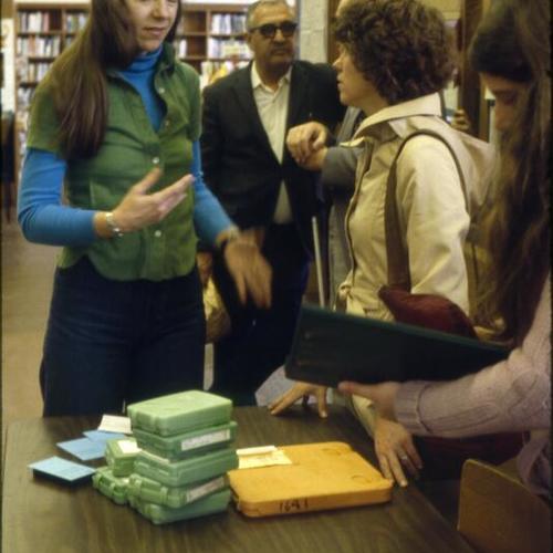 [Library staff assist a blind patron]