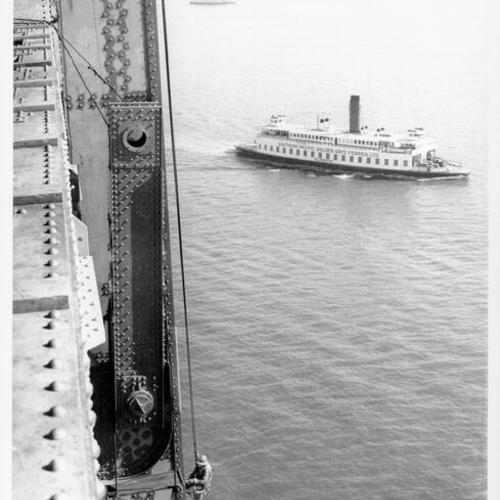 [Bridge worker hanging by rope from the side of the San Francisco-Oakland Bay Bridge]