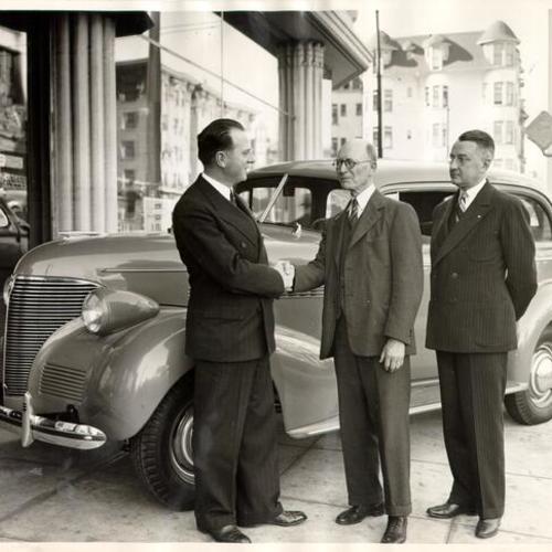 [Thomas Shaw picking up an automobile he won in a national contest from Ernest Ingold Chevrolet dealership]