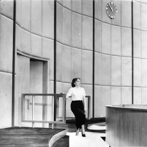 [Barbara Delbex standing in the newly renovated courtroom of the State Supreme Court]