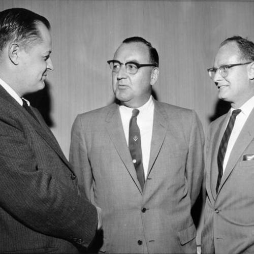 [Governor-elect Edmund G. Brown, center, talks it over with his newly appointed press secretaries Hale Champion, left, and Jerry Maher, during an informal dinner]