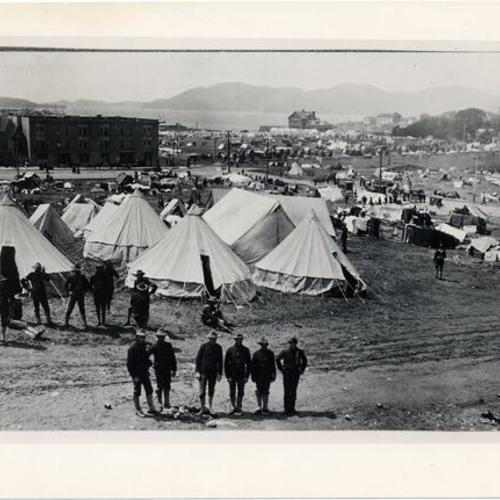 [Unidentified group of men in uniform standing in front of the refugee camp in the Marina, after the 1906 earthquake and fire]
