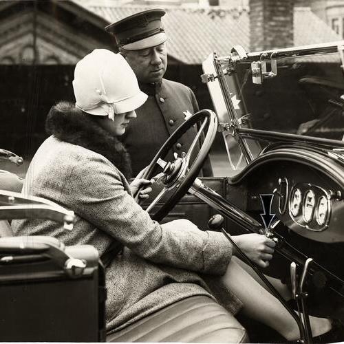 [Officer Nelson J. Mathewson observing a lady driver showing the theft locking device]