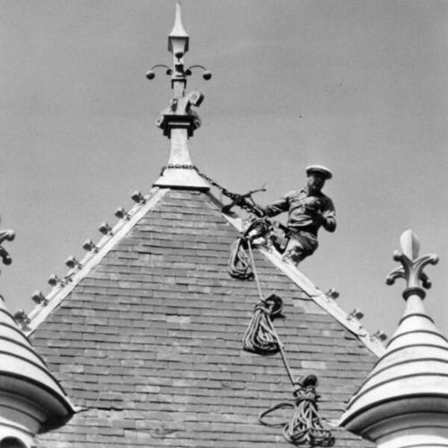 [Steeplejack Ralph Clark descending a steeple atop St. Mark's Lutheran Church]