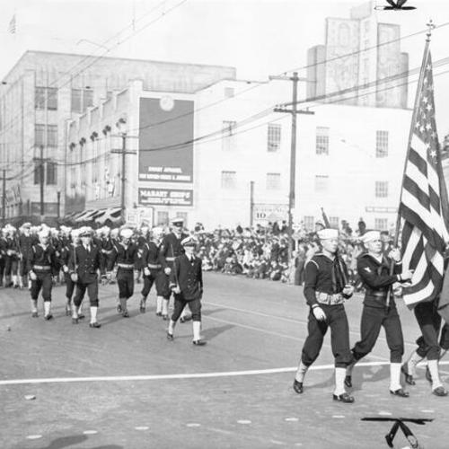 [Marching men of the United States navy passing by spectators on Broadway street, in oakland, in the opening day celebration parade for San Francisco-Oakland Bay Bridge]