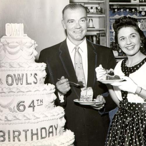[H. C. Bender and Alice Lon eating cake at a celebration of the Owl Drug Company's 64th "birthday"]