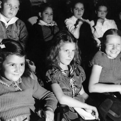 [Edison School students Marlise Osborne, Helen Tisingattis and Marilyn Vogel watching a theater production of "Little Red Riding Hood"]