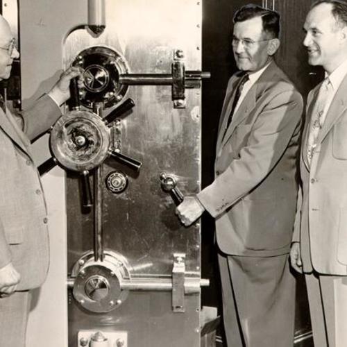 [Carl Haas, vice president of Herman Safe Company, standing with John R. Hermann senior and junior]