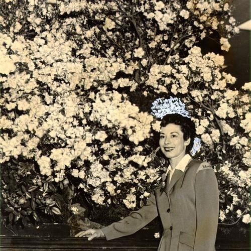 [Macy's employee Dorothy Conner posing with a floral display at the store's annual flower show]