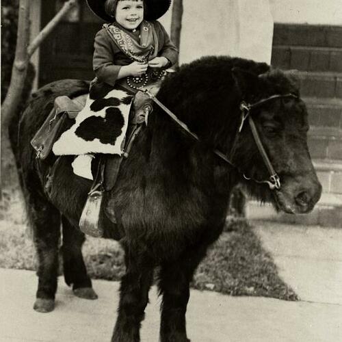[Judy in front of Broad Street riding a very furry pony]