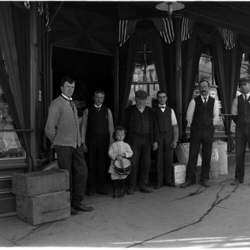 Heinecke Brothers Groceries with employees and child outside