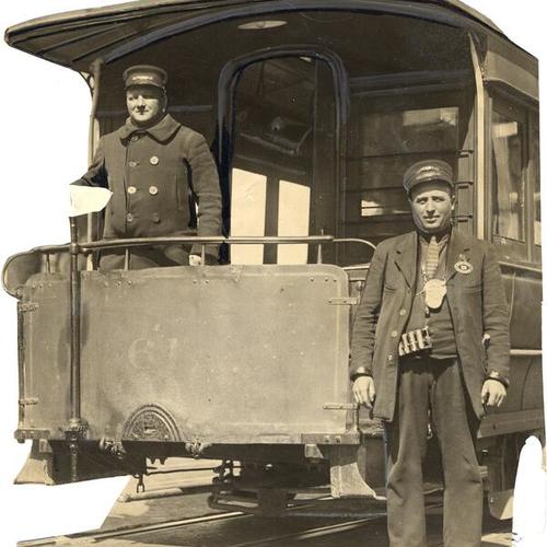 [J. Carnae and George Bothemann posing in front of Pacific Avenue cable car]