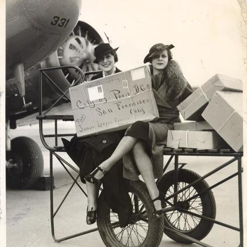 [Two unidentified women holding a package addressed to the City of Paris department store]