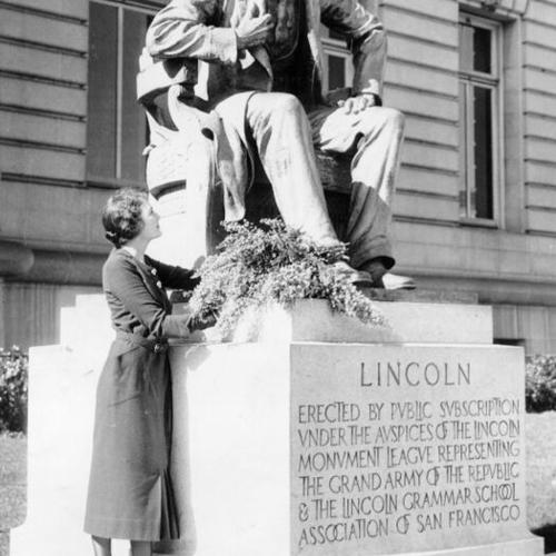 [Unidentified woman standing next to Abraham Lincoln monument at City Hall, San Francisco]