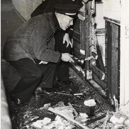 [Two firemen inspecting fire damage aboard the riverboat "Fort Sutter"]