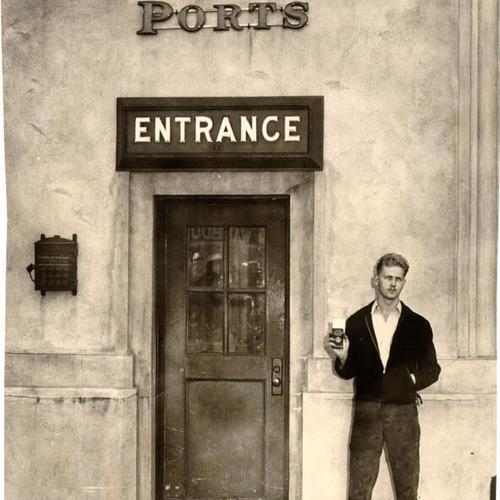 [Unidentified man standing next to an entrance to a pier at the San Francisco waterfront]