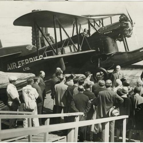 [A crowd of people waiting to board a seaplane operated by Air Ferries Ltd.]