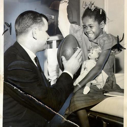 [Football player Ron Miller visiting with an eight-year-old patient at the Shriners' Hospital for Crippled Children]