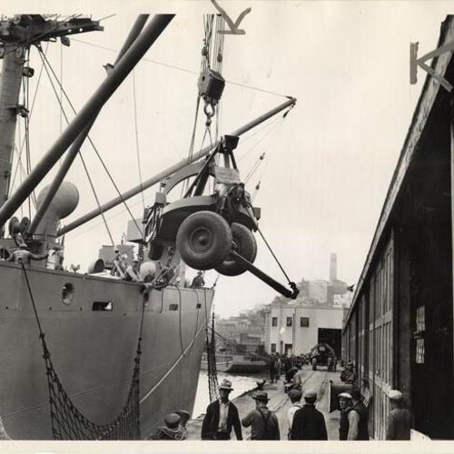 [Heavy military equipment being loaded onto a ship at the San Francisco waterfront]