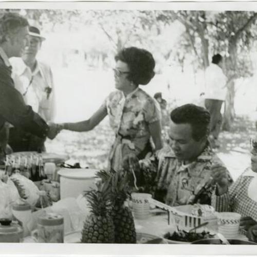 [George Moscone shaking hands with a woman at the Gran Oriente Filipino Masonic picnic in South Park]
