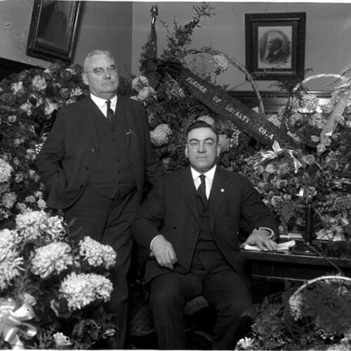 [San Francisco Police Chief D. O'Brien with floral wreaths and unidentified man]