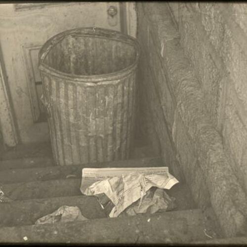 Trash can and litter left in stairway