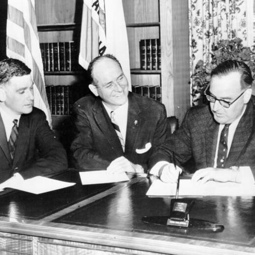 [Governor Mark Hatfield of Oregon, left, and Governor Albert Rosellini of Washington, center, watch Governor Edmund G. Brown of California sign a bill appropriating $70,000 for study of           possible use of Bonneville Dam electricity in California's 
