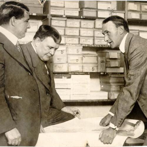 [Lieutenant-Colonel Thomas H. Reese, Lieutenant-Colonel Charles L. Potter and Major George B. Pillsbury looking at plans for a bridge between San Francisco and Oakland]