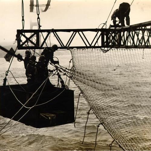 [Bridge workers securing a safety net during construction of the San Francisco-Oakland Bay Bridge]