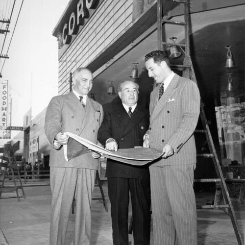 [Samuel H. Levin (center) meets with Michael Naify (left) and his son Irving M. Levin (right) to complete final touches on the Coronet theater]