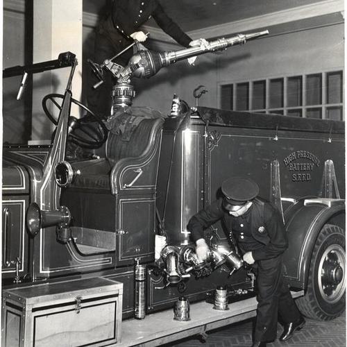 [Firemen Dan Darini and Bert Millisich of Truck 13 demonstrating a high pressure battery]