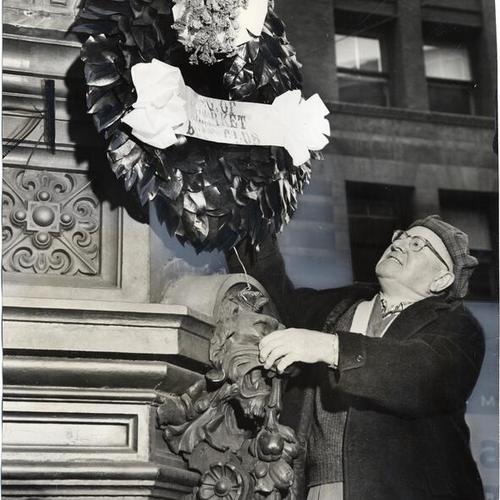 [Danny McDonald placing a wreath on Lotta's Fountain, at Third and Market streets, in commemoration of the 1906 earthquake and fire]