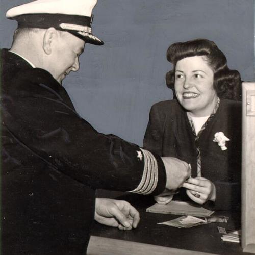 [U. S. Navy Captain G. B. Carter buying a railway ticket from Doris Tuttle at the Military Travel Bureau]