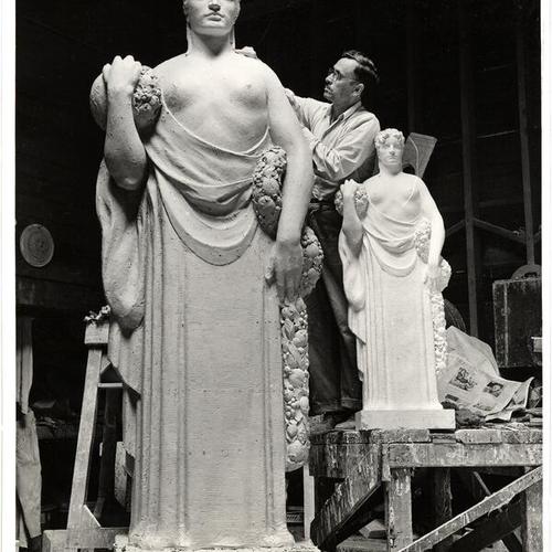 [Workman putting the finishing touches on figure 'Fruition' for final casting; statue by sculptor Haig Patigan to be seen in the Enchanted Gardens, Golden Gate International Exposition on Treasure Island]