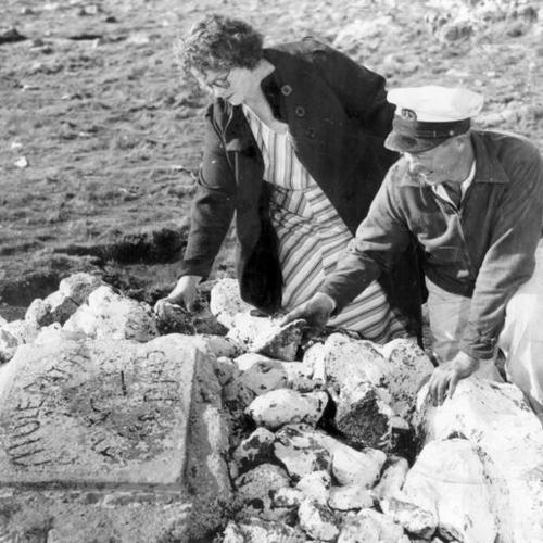 [Two people looking at the grave of "Patty the mule" on the Farallon Islands]