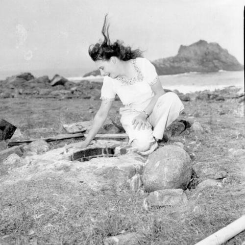 [Woman kneeling on the rocks of the Farallon Islands]