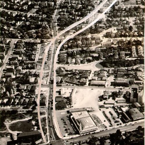 [Aerial view of Oakland looking east on Moss Avenue, from Broadway, with diagram showing planned six-lane highway connecting Oakland residential districts to the Bay Bridge]