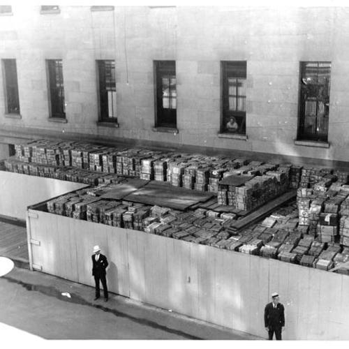 [60 millions in Chinese silver dollars stacked and guarded outside the old Mint building at Fifth and Mission street]