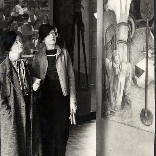 [Evelyn Sinclair and Mildred Heller viewing murals inside Coit Tower]