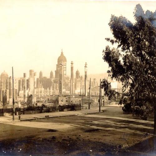 [Chimneys towering above the wreckage left by the 1906 earthquake, with the ruins of City Hall in the background]