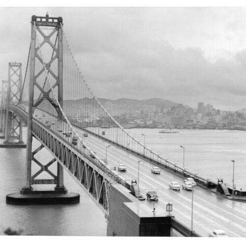 [Rain soaked suspension section of Bay Bridge with San Francisco in background]