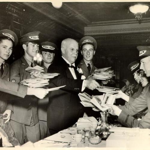 [Governor James Rolph, Jr. surrounded by Western Union delivery people during his 64th birthday party at the Hotel Whitcomb]