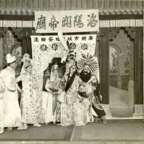 [Actors performing a production on stage in Chinatown]