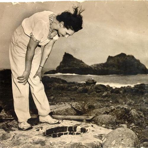 [Unidentified woman standing near the shore on the Farallon Islands]
